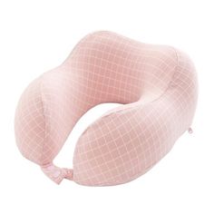 a pink neck pillow sitting on top of a white surface