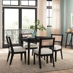 a dining room table with four chairs around it