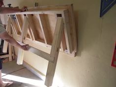 a man is working on a wooden bed frame