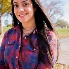 a woman with long dark hair wearing a plaid shirt