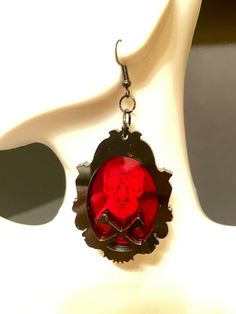 Get ready for Halloween with these eye-catching Sugar Skull and Crossbones Framed Earrings! Crafted from red mirrored acrylic and black acrylic, the laser engraved sugar skull design and laser cut frame with crossbones make for a striking and unique accessory. Show off your gothic style and add an edgy touch to any outfit with these must-have earrings! Each earring is made with 2 layers of 3MM acrylic, but are VERY LIGHT WEIGHT!French hook with silicone stoppers. Earrings are 2" X 1.5" long. *** Goth Ren Faire, Sugar Skull Design, Mirrored Acrylic, Red Mirror, Ready For Halloween, Earrings Red, Skull And Crossbones, Black Acrylic, Black Acrylics