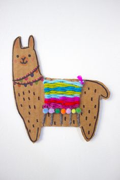 a llama ornament made out of felt with beads and yarn on it