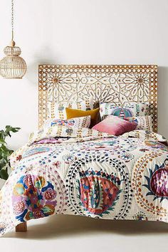 a bed with an intricately designed headboard and pillows