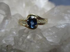 This 14K Gold Ring is set with a beautiful gem grade Sapphire and accented with Diamonds. The Oval Cut Sapphire has great blue color. Not too dark and not too light. It measures 5.5 mm by 4.5 mm and weighs .66 carat. It is a clean, well cut natural stone. There are 8 accenting Diamonds, 4 on each side. The accent Diamonds weigh .05 carat total weight. The ring is about 5/16 inch wide on top and tapers to a narrow band in the back. Low profile settings make this a very wearable ring. It is made i Luxury Yellow Gold Gia-certified Sapphire Ring, Star Sapphire Cabochon Ring, Exquisite Gia-certified Platinum Sapphire Ring, Gia Certified Square-cut Sapphire Jewelry, Star Sapphire Gemstone, Sapphire Diamond Ring, 14k Gold Ring, Sapphire Diamond, Sapphire Ring