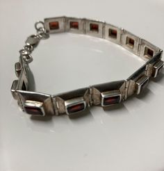 This is a beautiful vintage sterling silver bracelet with large baguette cut red garnets on each link. The stones have an excellent deep red and slight brown color. It weighs about an ounce and measures 9".  I'm not sure what year this was made, but it is most likely early-mid 20th century. Possibly American, Mexican, or Indian in origin. Bolo Ties, Berets, Baguette Cut, Tie Accessories, Vintage Modern, Vintage Bracelets, Sterling Silver Bracelet, Red Garnet, Deep Red