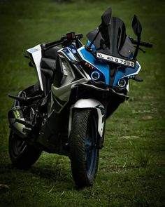 a blue and white motorcycle parked in the grass