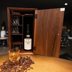 a bottle of whisky sitting next to a glass filled with coffee beans