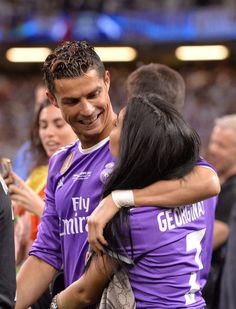 two soccer players hugging each other in the middle of a crowd at a sporting event