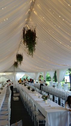 the inside of a tent with tables and chairs set up for a formal dinner party