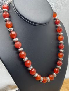 "Carnelian gemstone necklace with silk spaces.   Round 10mm beads 22\" long Carnelian Gemstone Healing  - Powerful healing stone that works on all Chakras to balance the mind, body, and spirit.  - Removes negative energy and allows positive to flow through." Luxury Carnelian Gemstone Beads Necklace, Silver Carnelian Beaded Necklace With Gemstone Beads, Round Carnelian Necklace With Polished Beads, Silver Beaded Carnelian Necklaces, Silver Carnelian Beaded Necklace, Silver Beaded Carnelian Necklace, Carnelian Gemstone Beads Necklaces For Meditation, Spiritual Carnelian Round Bead Necklaces, Spiritual Carnelian Round Beads Necklace