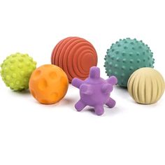 several different colored balls and toys on a white background