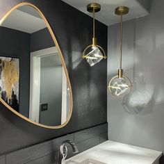 a bathroom with a sink, mirror and lights on the wall next to each other