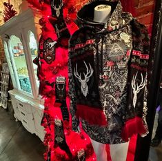 a mannequin dressed in black and red clothing with deer heads on it's chest