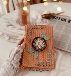 a crocheted book with a flower on it sitting on top of a table