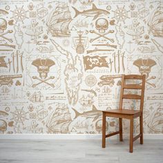 a wooden chair sitting in front of a wall covered with pirate themed wallpapers