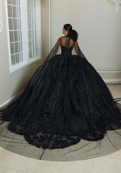 We are obsessing over this all black Quinceanera that just screams uniqueness! 89482, is a stunning ballgown with a blingy corset bodice that will accentuate your waistline and have you sparkling all night long. The delicate lace details that flow onto the sparkling tulle skirt that's completed with a petal train and lets not forget about the mesmerizing bow on the back! This is perfect for your Quince day! For additional details on this ballgown, give us a call at Terry Costa or chat with us! All Black Quinceanera, Black Wedding Ball Gown With Boned Bodice, Black Gown For Quinceanera, Black Evening Dress With Corset Back For Debutante Ball, Black Boned Bodice Dress For Debutante Ball, Glamorous Fitted Gown For Quinceanera, Black Ball Gown With Boned Bodice, Elegant Black Dress For Quinceanera, Black Dress With Corset Back For Debutante Ball