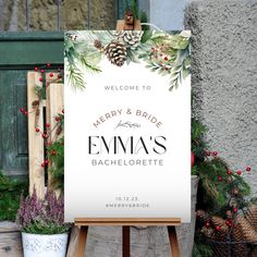 a welcome sign with pine cones and evergreens on it in front of a building