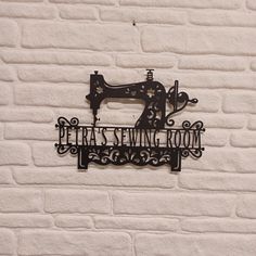 there is a metal sign that says peta's sewing room on the wall