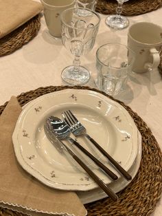 the table is set with silverware and place settings