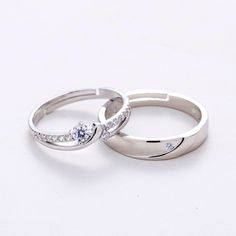 two white gold wedding rings with diamonds on top and the middle one has a round brilliant cut diamond