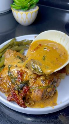 a white plate topped with meat covered in gravy