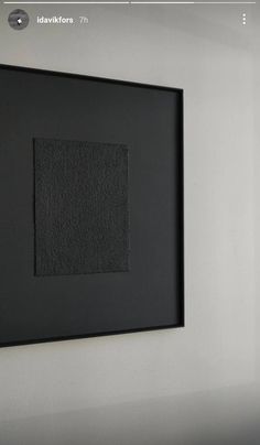 a black square is hanging on the wall