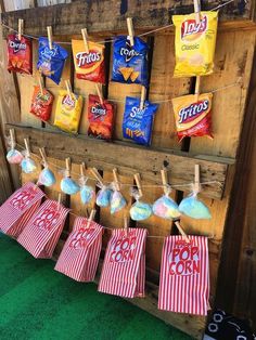 the back yard movie party is set up with popcorn bags and candy bars on clothes pins