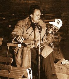 a man sitting in front of a microphone holding a skull