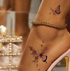 a woman's foot with a butterfly tattoo on the side of her leg and ankle