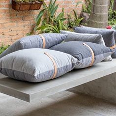 three pillows are sitting on a concrete bench