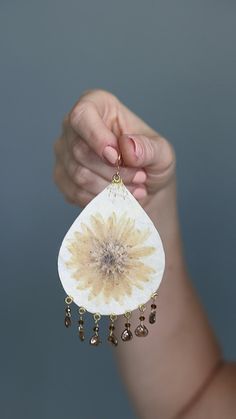 White teardrop shaped earrings with pressed flower focal points and Czech glass drops created using a silk fusion technique Bohemian Dangle Earrings With Pressed Flowers, Bohemian Pressed Flowers Drop Earrings, Bohemian Drop Earrings With Pressed Flowers, Bohemian Drop Earrings With Natural Inclusions, White Nature-inspired Drop Earrings, Nature-inspired White Drop Earrings, Bohemian Pressed Flower Earrings, Bohemian Flower Earrings With Pressed Flowers, Bohemian White Jewelry With Natural Inclusions