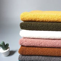 a stack of towels sitting next to a cactus