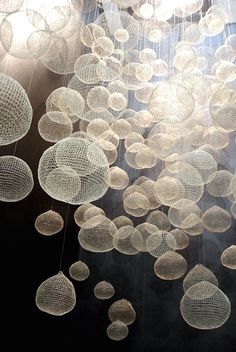 a chandelier hanging from the ceiling with lots of white bubbles floating in it