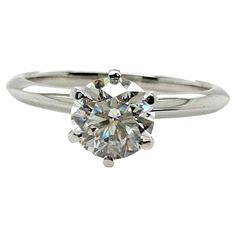 a white gold ring with a round cut diamond