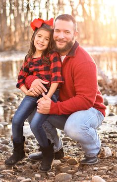 a father and daughter pose for a photo in the woods