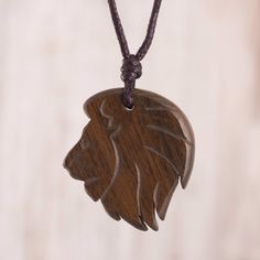 a wooden necklace with a lion head on it