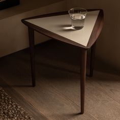 a table with a glass on it and a rug in front of the table top