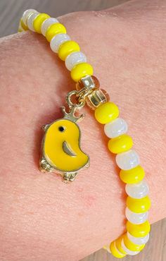 a close up of a person's arm wearing a bracelet with an elephant charm