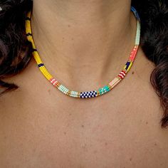 a woman wearing a multicolored beaded necklace on her left neck and chest