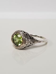 Once in a Blue Moon beautiful vintage finds. Antique Peridot Filigree Ring // Solid 925 Sterling Silver. Antique Remake. Ethical, lab created gemstone. Elegant mid-century style filigree and carving. Size: 6, 8, 9, 10 US * Message me for sizing options Weight: 2.0 g Stone: 1.0 ct (6.5 mm) Band width: 1.2 mm Free shipping, comes packaged in a ring box ready to gift! Vintage Sterling Silver Filigree Ring With Intricate Design, Vintage Sterling Silver Filigree Ring, Ornate Filigree Ring Stamped 925 For Anniversary, Antique Filigree Ring With Center Stone As Gift, Ornate Filigree Ring For Anniversary, Stamped 925, Art Deco Filigree Ring With Center Stone As Gift, Elegant Filigree Ring With May Birthstone, Green Filigree Ring For Anniversary, Elegant Filigree Ring As May Birthstone Gift