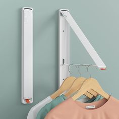 clothes hanging on hangers in front of a wall mounted garment rack and door handle