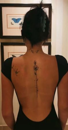 the back of a woman's body with tattoos on her upper and lower back