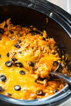 a crock pot filled with black olives and chicken enchilada casserole