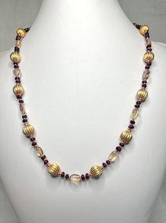 This stunning necklace is suitable for festive occasions and the business world alike. It is made using significant amounts of citrine and garnet, and is accented with 10 mm gold-tone fluted beads. The length is 20 1/2 inches, and it is secured with a lobster-claw clasp. Garnet And Gold, Wedding Jewellery Necklace, Stunning Necklace, Wedding Necklace, Lobster Claw, Citrine, Garnet, Wedding Jewelry, Gold Tones