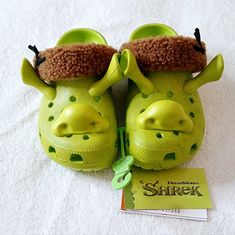 a pair of green shoes sitting on top of a white towel next to a book