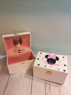 two pink and white boxes with minnie mouse designs on them, one has a ring in it