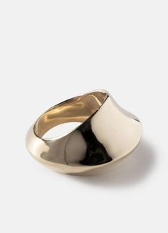 a gold and silver ring sitting on top of a white surface