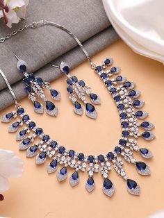 Add a touch of glamour and sophistication with this high quality necklace set in beautiful  sapphire blue stones. The stones in this set bling and look close to the real thing. This set is sure to make heads turn!  It features an adjustable necklace and a pair of earrings. It can be paired perfectly with both ethnic and western outfits.  In case of any queries, please feel free to reach out. Happy shopping! Necklace weight: 70 gms Length :16 inches Adjustable length with a metal chain at the bac Fine Jewelry Sapphire Jewelry For Party, Fine Jewelry With Blue Stones, Blue Fine Jewelry With Stones, Blue Formal Jewelry With Stones, Formal Blue Jewelry With Stones, Sapphire Crystal Jewelry For Wedding, Fine Blue Jewelry With Stones, Formal Blue Stone Jewelry, Blue Stones Fine Jewelry