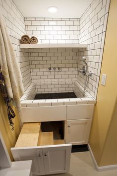 a bathroom with white tile and black counter tops