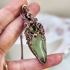 This wire wrapped jade crystal necklace with deep green cubic zirconia accent is made with pure copper wire that has been meticulously hand shaped, hammered, filed, sanded, antiqued, and polished to a high shine, and comes on your choice of black cord or chain. Please note that natural materials and crystals display different color properties depending on lighting. I try to take all my photos in a combination of sunlight and shade to reflect different color play. Colors also may vary or show up Green Copper Hand Wrapped Necklaces, Green Hand Wrapped Copper Necklace, Jade Wire Wrapped Pendant Jewelry, Green Wire Wrapped Necklace For May Birthstone, Green Electroformed Bohemian Jewelry, Green Moss Agate Bohemian Jewelry, Bohemian Green Electroformed Jewelry, Green Bohemian Electroformed Jewelry, Green Hand Wrapped Nature-inspired Necklaces